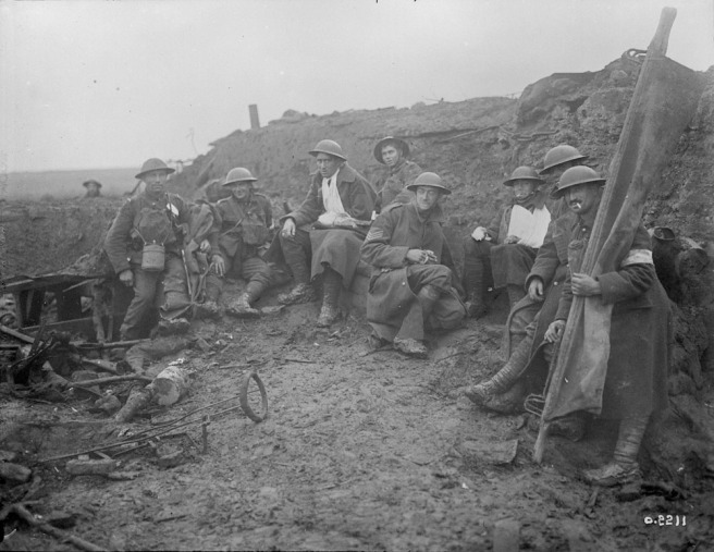 Wounded Canadians taking cover behind pill-box. Battle of Passchendaele. November, 1917.